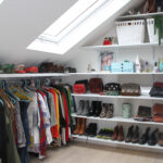 Stylish loft conversion walk-in closet with skylight and organized shelving. Perfect space optimization for modern homes.