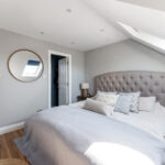 Modern loft conversion bedroom with skylight, stylish decor, and cozy furnishings. Perfect extra living space solution.