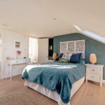 Bright, cozy loft conversion bedroom with modern decor and skylight. Perfect use of attic space for luxury living.