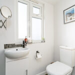 Modern loft conversion bathroom with white fixtures and sleek design. Perfect use of small space for added functionality.