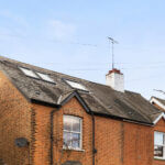 Modern loft conversion with skylight windows on a brick house roof. Perfect for extra living space and natural light.