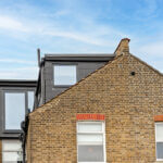 Modern loft conversion with sleek windows on a residential building, showcasing enhanced living space.