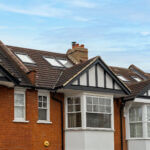 Modern loft conversion with skylights on a stylish brick house in suburban neighborhood.