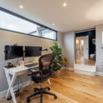 Modern loft conversion home office with dual monitors and stylish decor. Perfect for working from home.