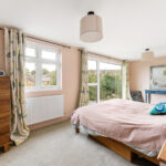 Bright, modern loft conversion bedroom with large windows and stylish decor. Perfect space for cozy living.