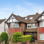 Detached house with dormer loft conversion and skylights, showcasing enhanced living space.
