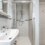 Modern loft conversion bathroom with sleek shower and stylish tiles. Perfect space optimization for small areas.