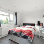 Modern loft conversion bedroom with cozy bed, desk, and natural light. Perfect for maximizing space in small homes.
