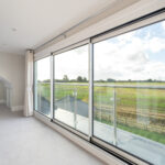 Modern loft conversion with panoramic countryside views through large sliding doors. Bright and spacious interior.