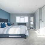 Modern loft conversion featuring a cozy bedroom with blue tones and stylish decor. Perfect for maximizing space.