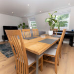 Stylish loft conversion dining area with wooden table, plants, and modern decor. Bright and airy space design.